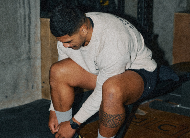 Athlete sitting and resting on a gym bench