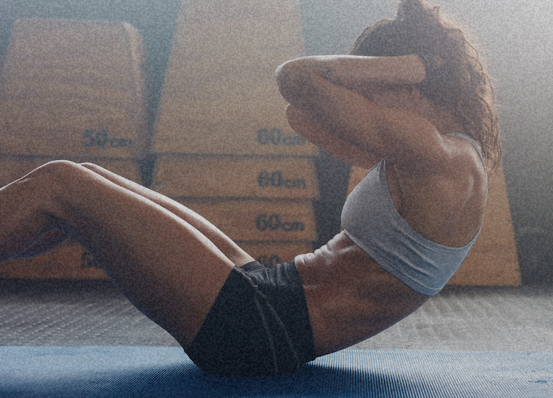 Woman doing core sit-ups in a gym