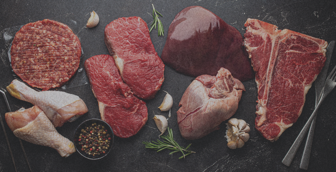 Selection of raw red meats and offal on a slate board