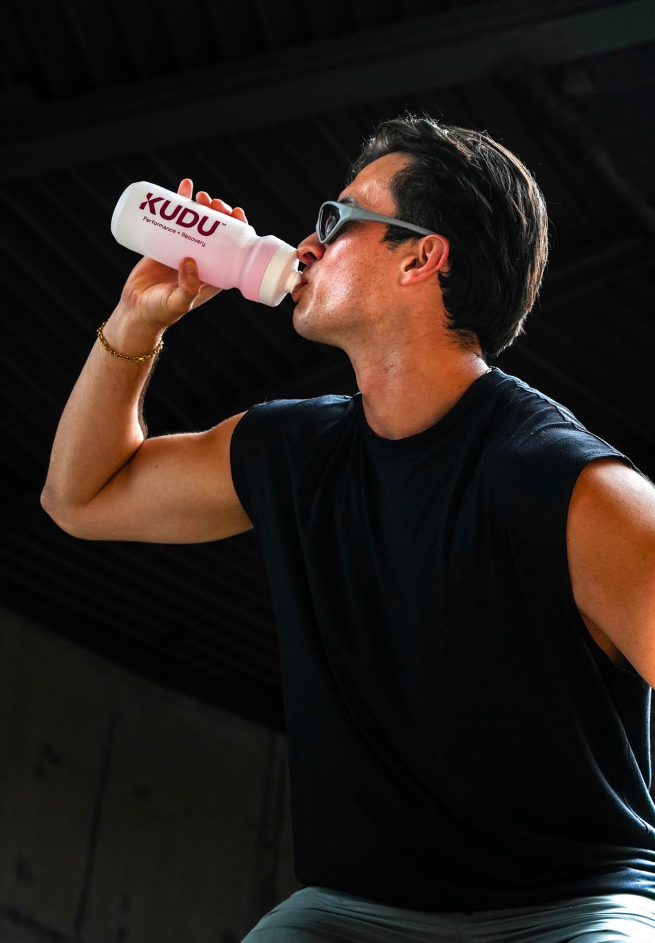 Athlete drinking from the Cream White KUDU Water Bottle