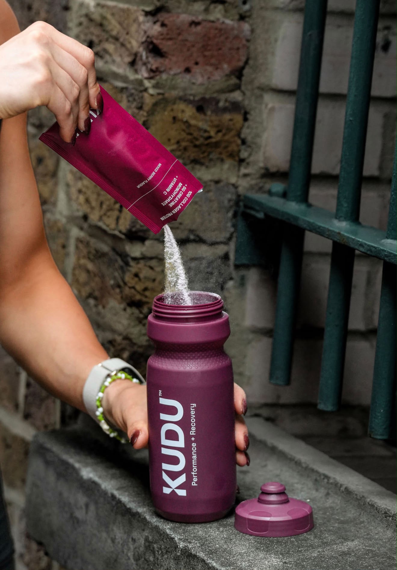 Pouring a KUDU sachet into the Aubergine KUDU Water Bottle