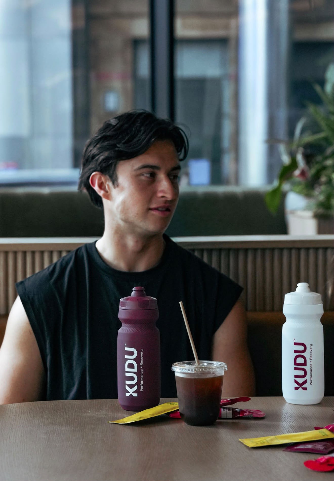 KUDU Water Bottles in Aubergine and Cream White at a cafe table